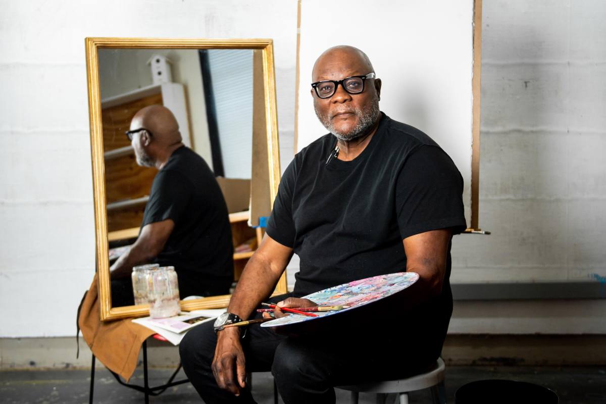 A portrait of an artist seated with palette in hand, a blank canvas ready behind him