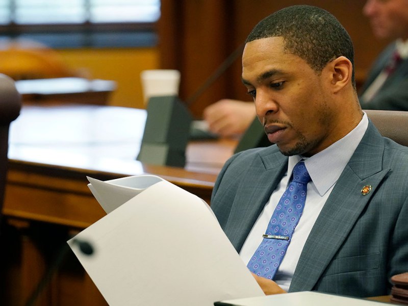 a man in a suit sitting at a desk reads a document