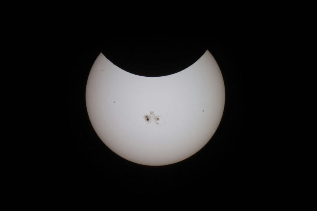 A photo of a solar eclipse. The moon is beginning to block some of the Sun.