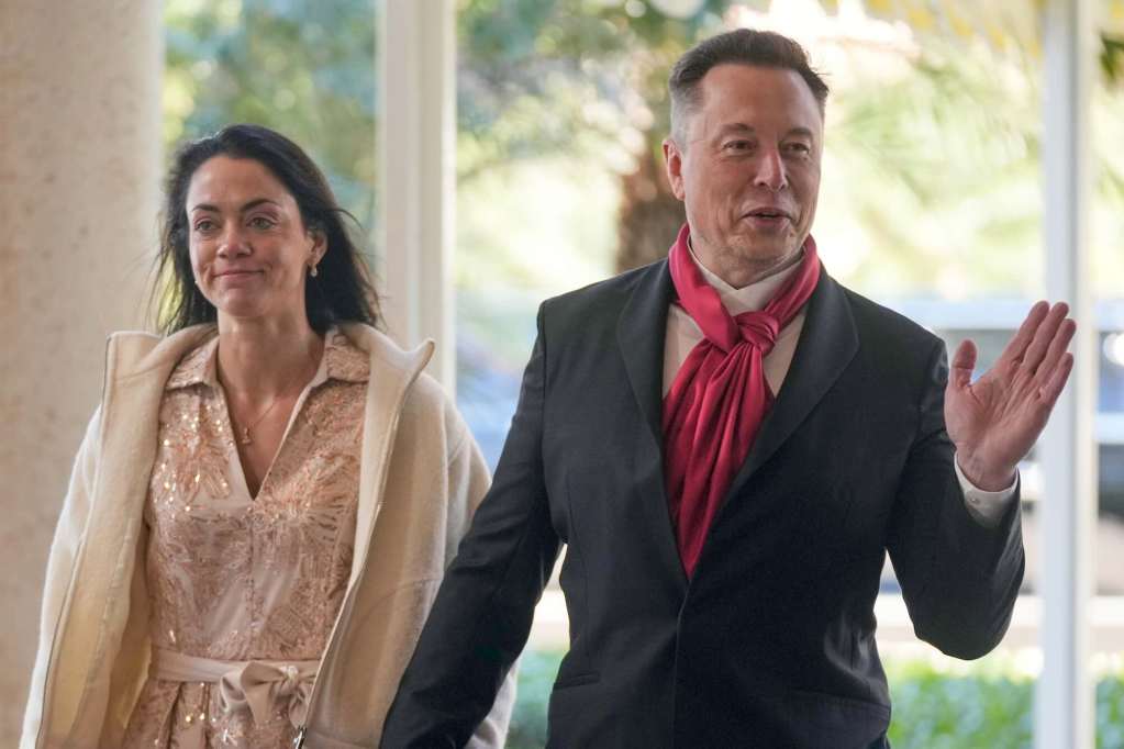 Elon Musk in suit and red scarf walks into Mar-A-Lago with Shivon Zillis in a gold dress