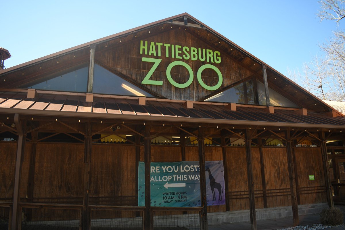 The front of a wooden building at the Hattiesburg Zoo is visible near the parking area.