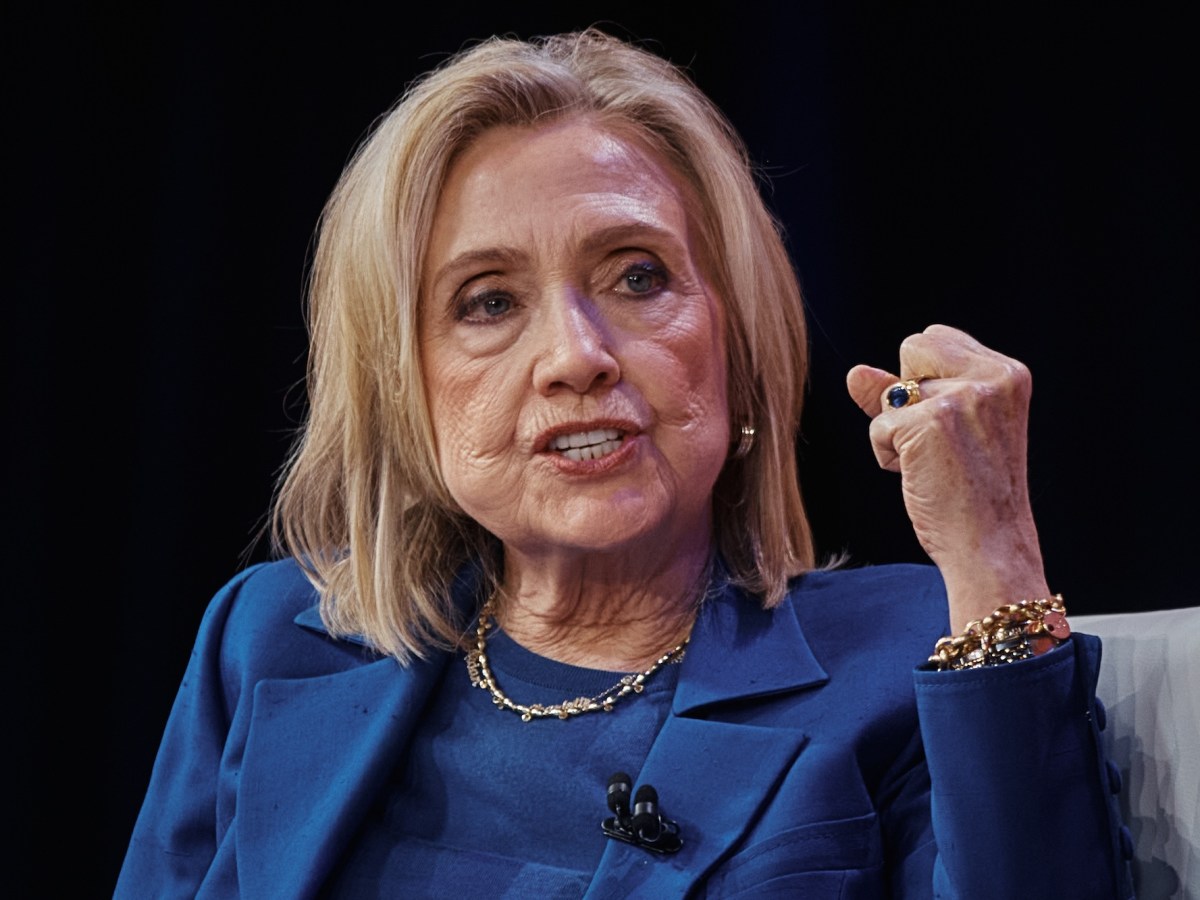 a photo of Hillary Clinton in a blue suit raising her first