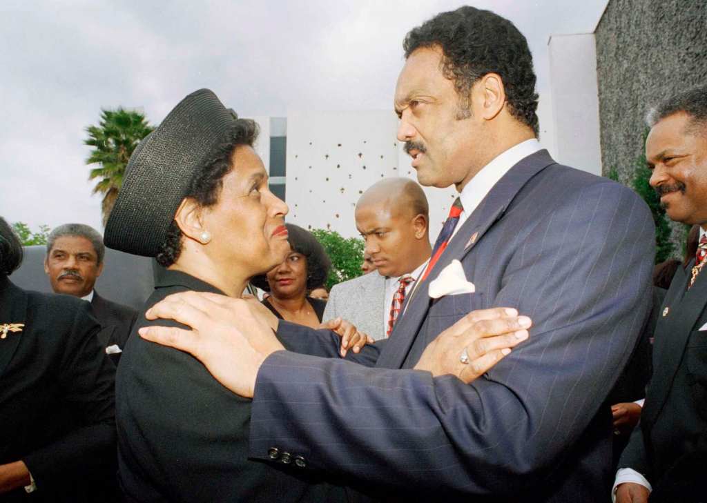 Jesse Jackson, right, embraces Myrlie Evers-Williams outside at a funeral