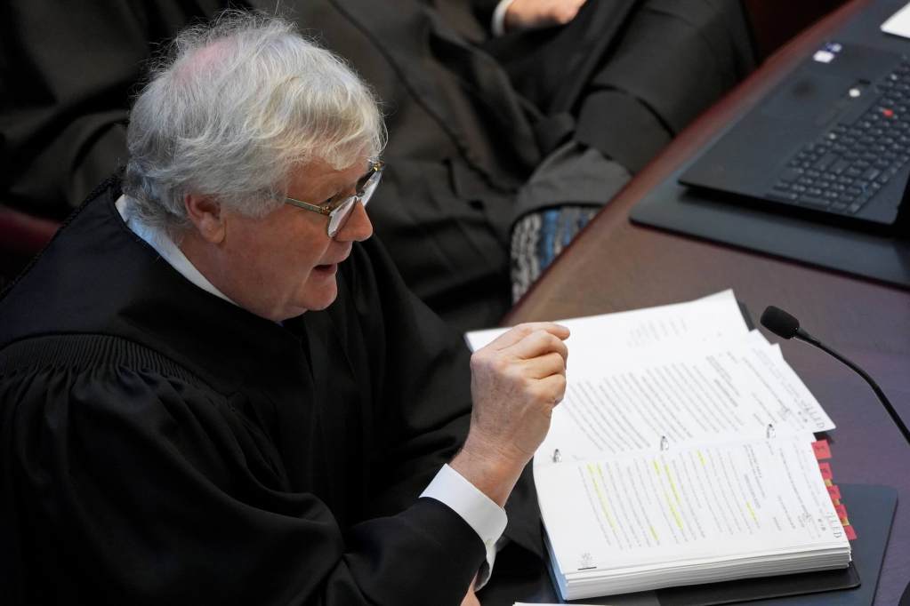 Associate Justice Kenneth Griffis in black robes speaks from behind the bench