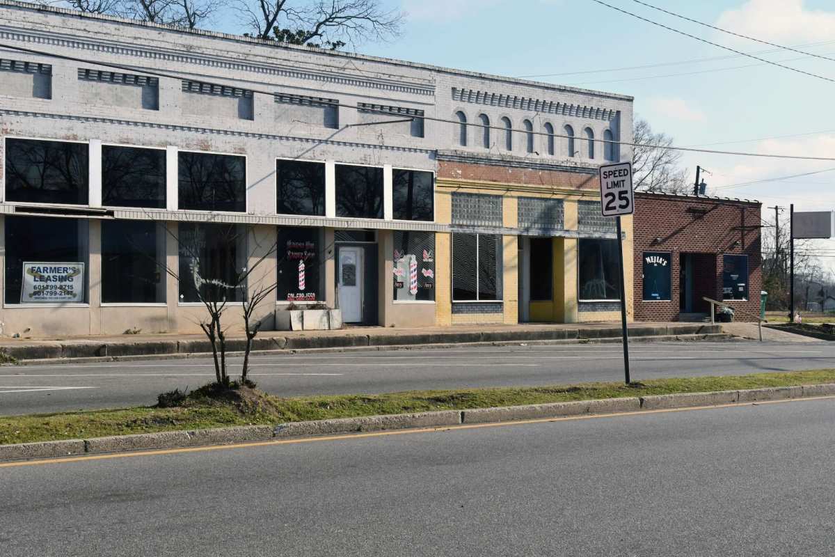 A row of vacant storefronts seen across the street