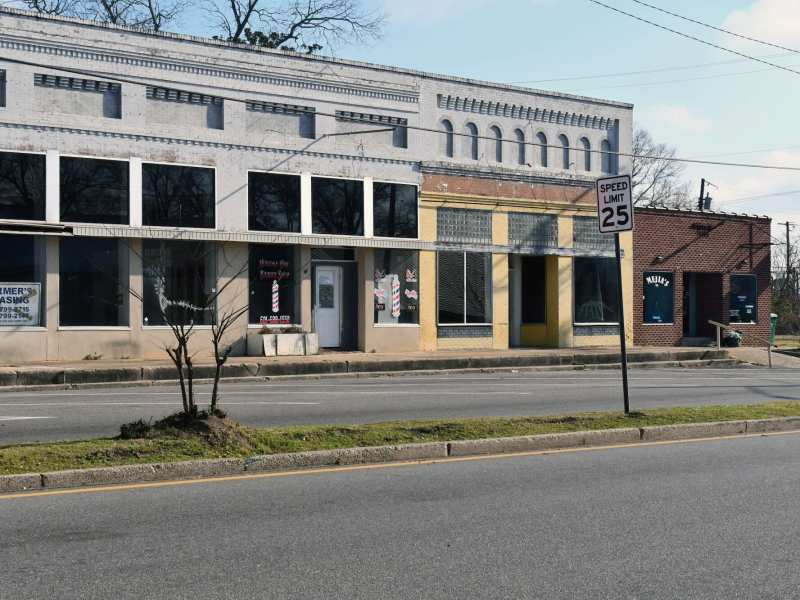 A row of vacant storefronts seen across the street