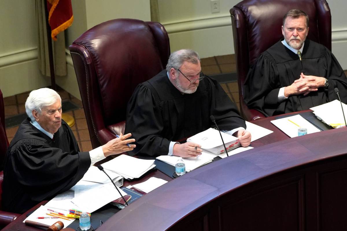 Three justices listening and speaking from their seats behind the bench