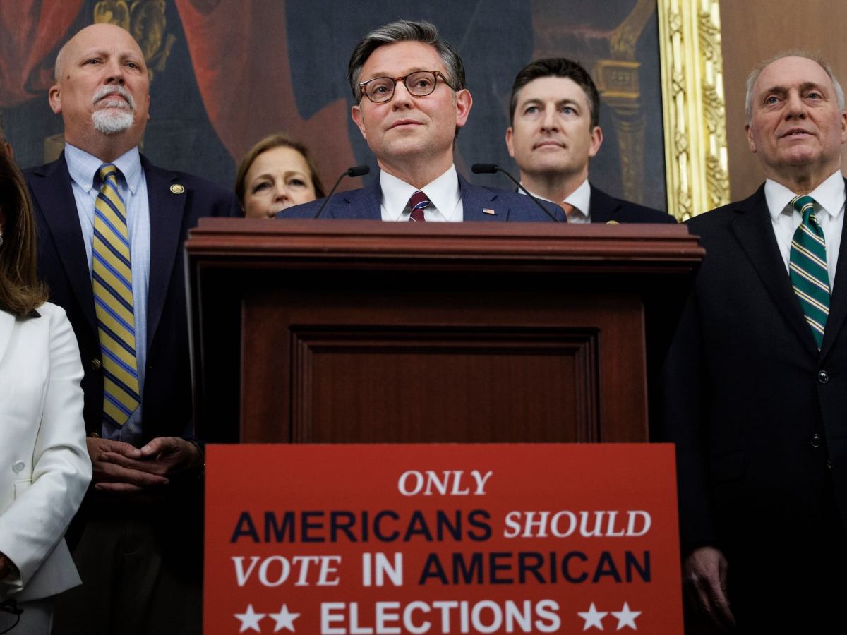Mike Johnson and other political figures stand behind a podium labeled 'Only Americans Should Vote in American Elections'