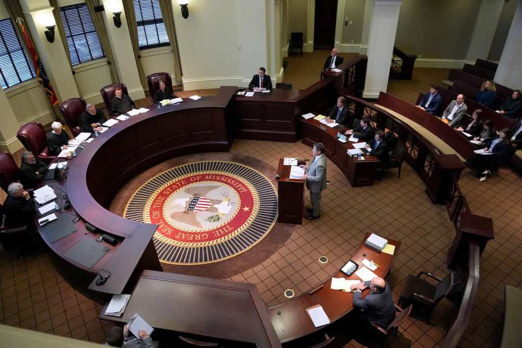 The Mississippi Supreme Court seated in a circular bench presiding over a case