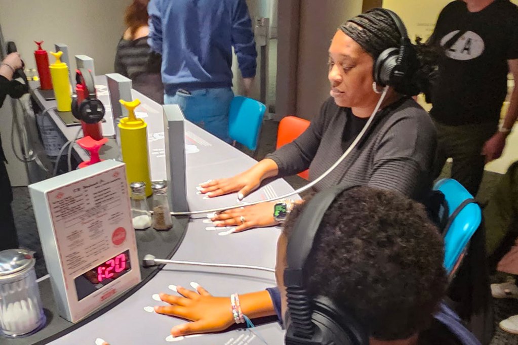 mother and son sitting at lunch counter museum exhibit
