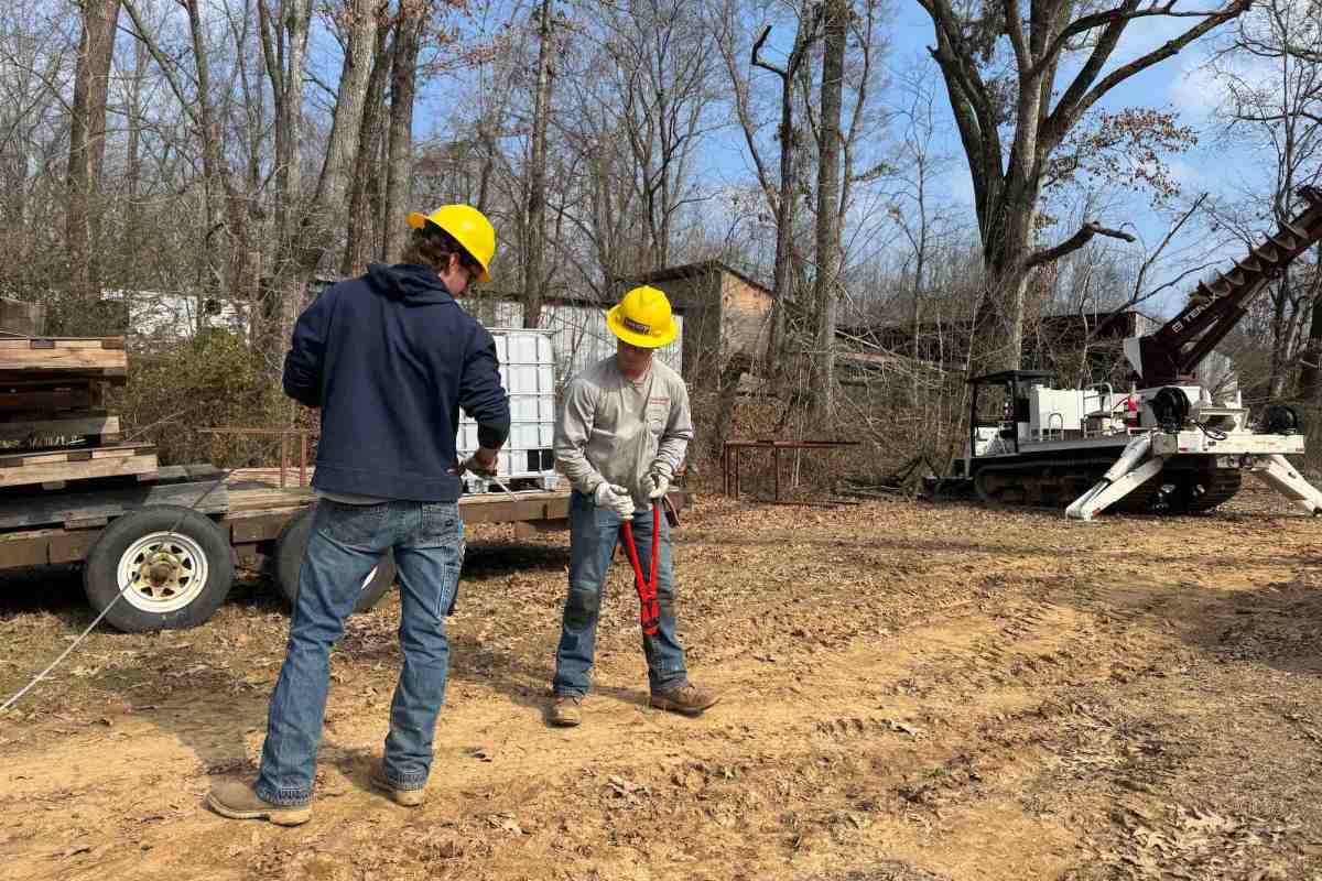 Two linemen work on downed power lines
