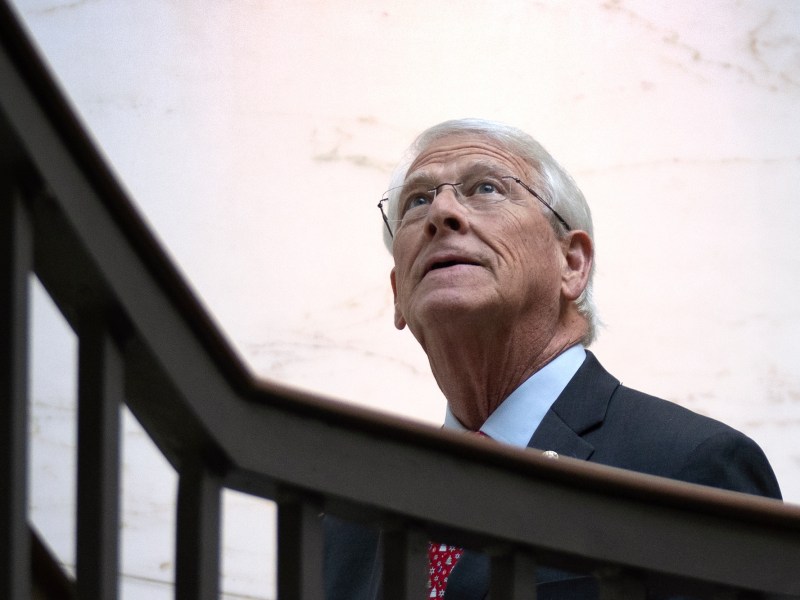 Roger Wicker, a man with white hair, looks up as he walks up a set of stairs