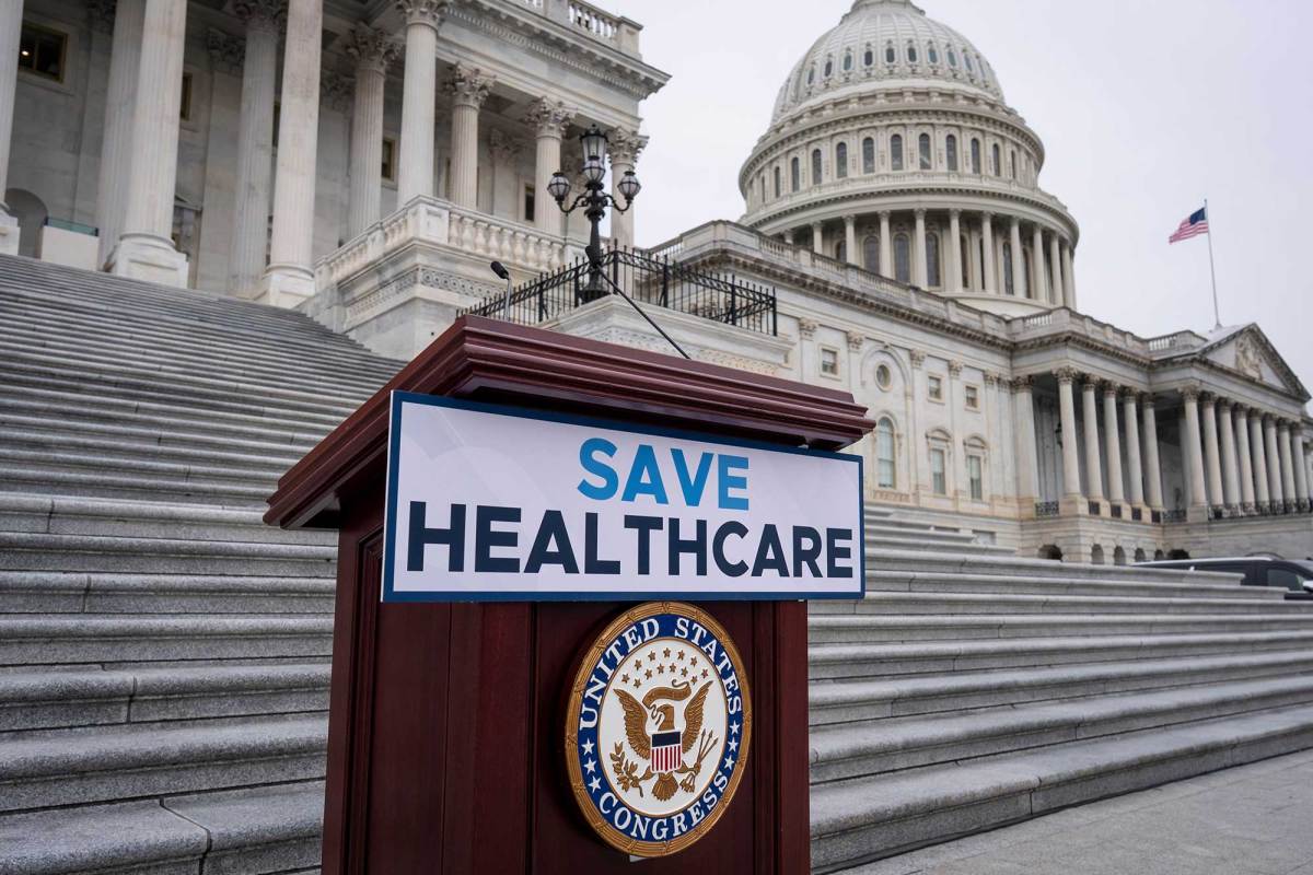 A wooden podium with a sign that says, “Save Healthcare.” The U.S. Capitol building is in the background.
