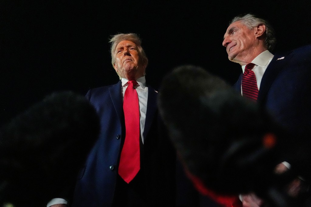 a photo shows donald trump and doug burgum from a ground level view looking up