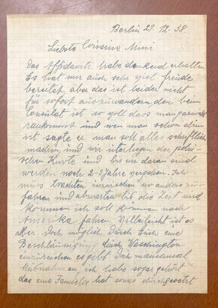 A faded, handwritten letter in blank ink, positioned against a brown surface.