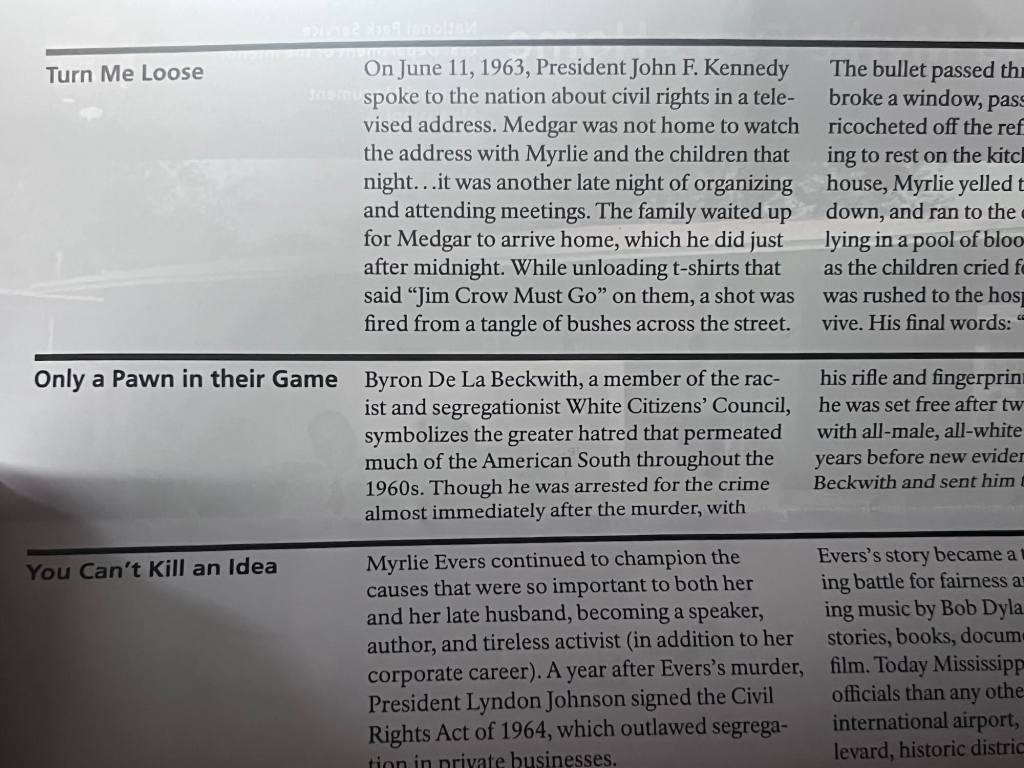 text of a brochure says: On June 11, 1963, President John F. Kennedy spoke to the nation about civil rights in a televised address. Medgar was not home to watch the address with Myrlie and the children that night...it was another late night of organizing and attending meetings. The family waited up for Medgar to arrive home, which he did just after midnight. While unloading t-shirts that said "Jim Crow Must Go" on them, a shot was fired from a tangle of bushes across the street. Byron De La Beckwith, a member of the racist and segregationist White Citizens Council, symbolizes the greater hatred that permeated much of the American South throughout the 1960s. Though he was arrested for the crime almost immediately after the murder, with Myrlie Evers continued to champion the causes that were so important to both her and her late husband, becoming a speaker, author, and tireless activist (in addition to her corporate career). A year after Evers's murder, President Lyndon Johnson signed the Civil Rights Act of 1964, which outlawed segrega-Ann parte businesses.
