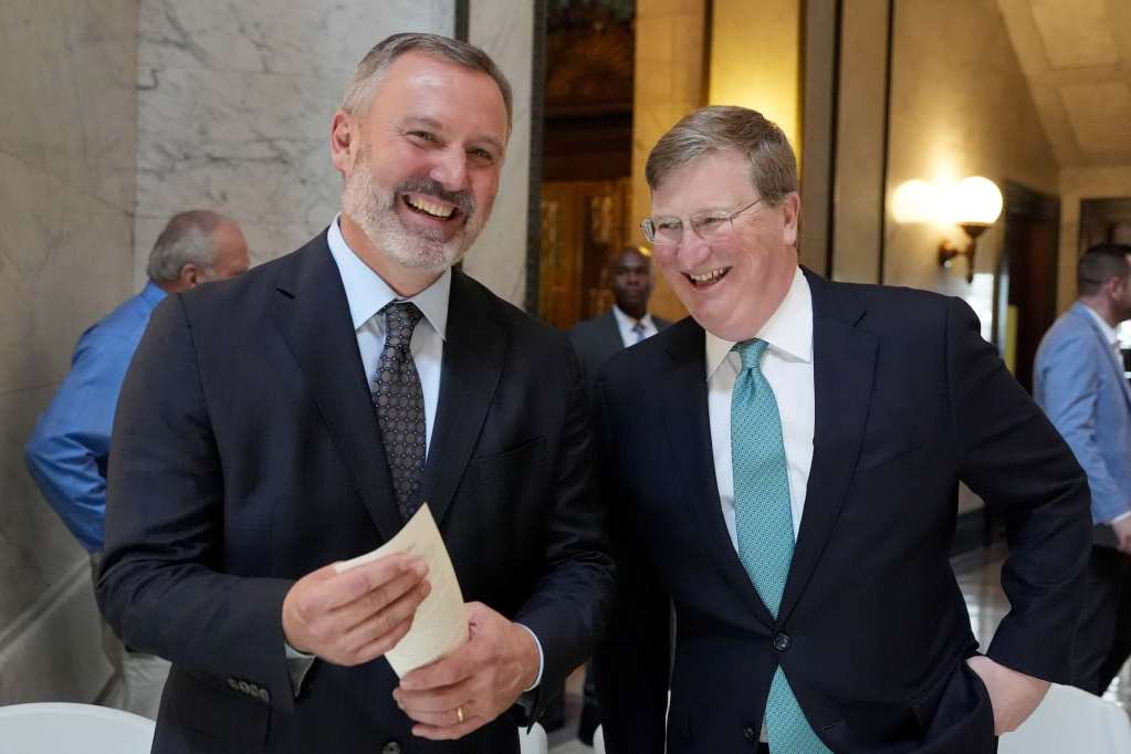 Jason White and Tate Reeves stand together, laughing at an event