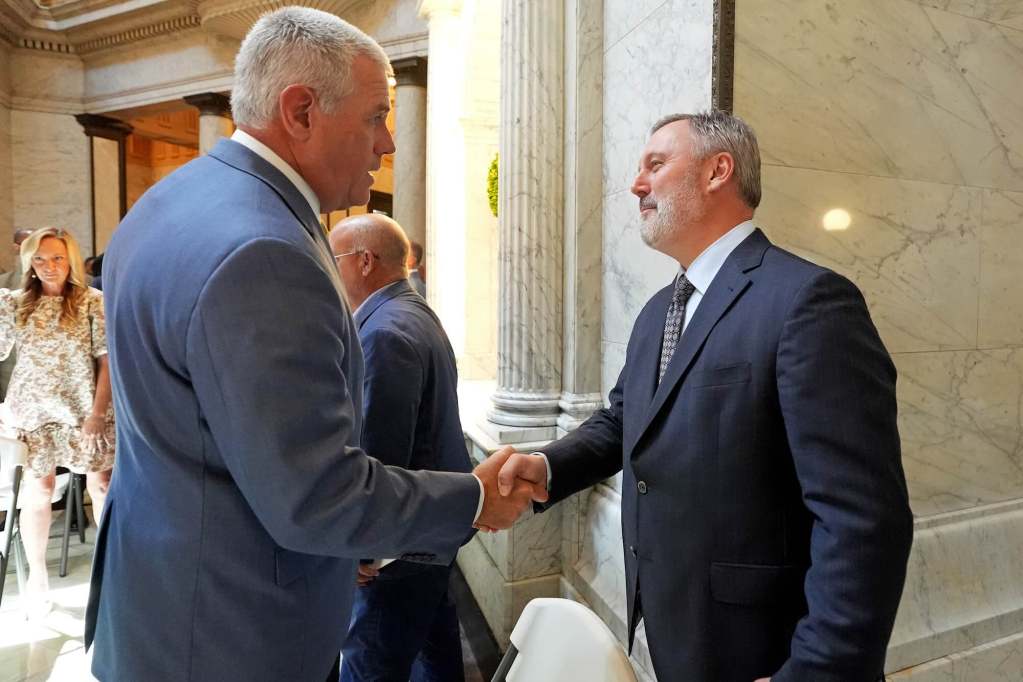 Philip Gunn and Jason White shake hands in the doorway of an event