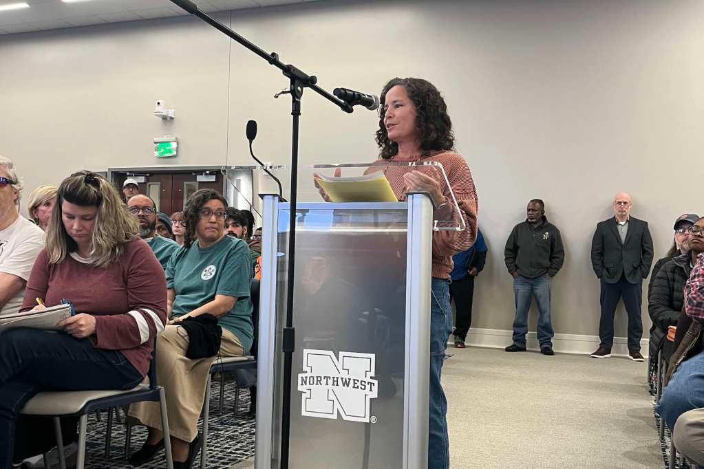 A woman speaks at a podium and speaks at a meeting