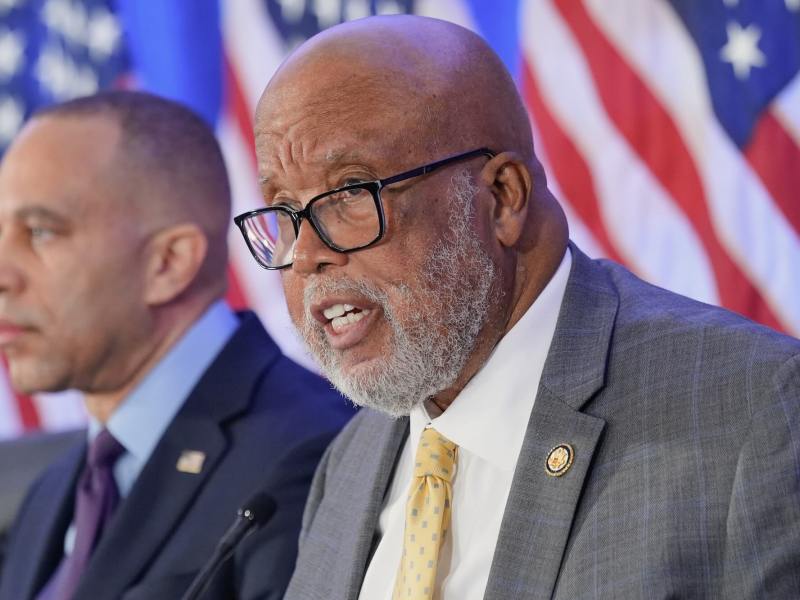 A closeup of Bennie Thompson speaking at a conference, US flags behind him
