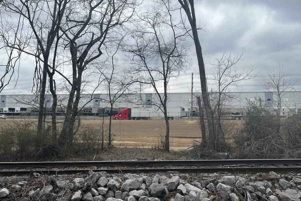 A data center can be seen past a railroad track and some trees