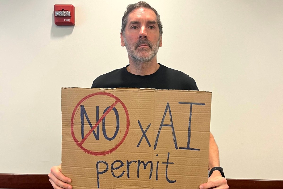 A man holding a sign that says No xAI permit