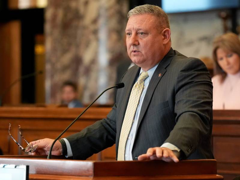 Dennis DeBar Jr. speaks at the legislature, glasses in hand