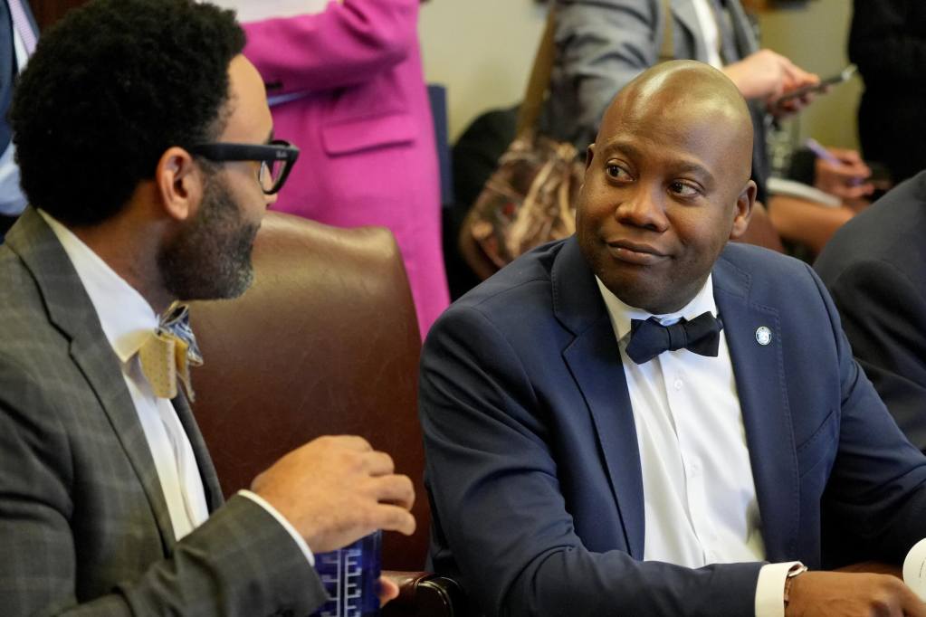 Derick Simons listening to Rod Hickman while they are both seated during a meeting