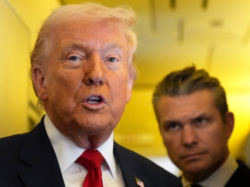 Donald Trump speaking with Pete Hegseth behind him