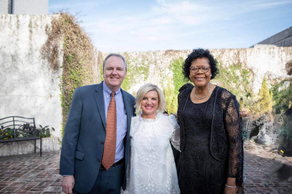Elayne Hayes-Anthony posing in a daylit courtyard with two other people