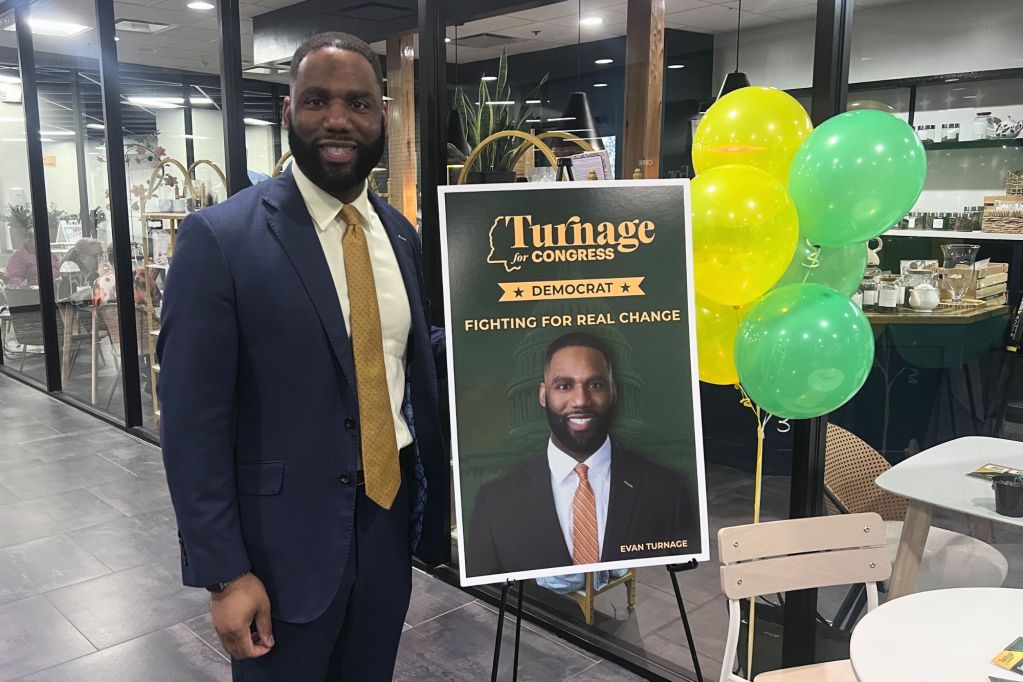 Evan Turnage standing beside his own election sign