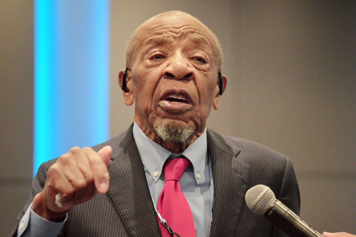 John M. Perkins speaking into a microphone at a podium