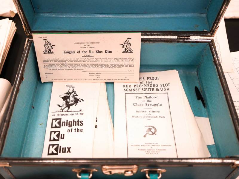 An open briefcase with blue interior, filled with pamphlets for 'Knights of the Ku Klux Klan'