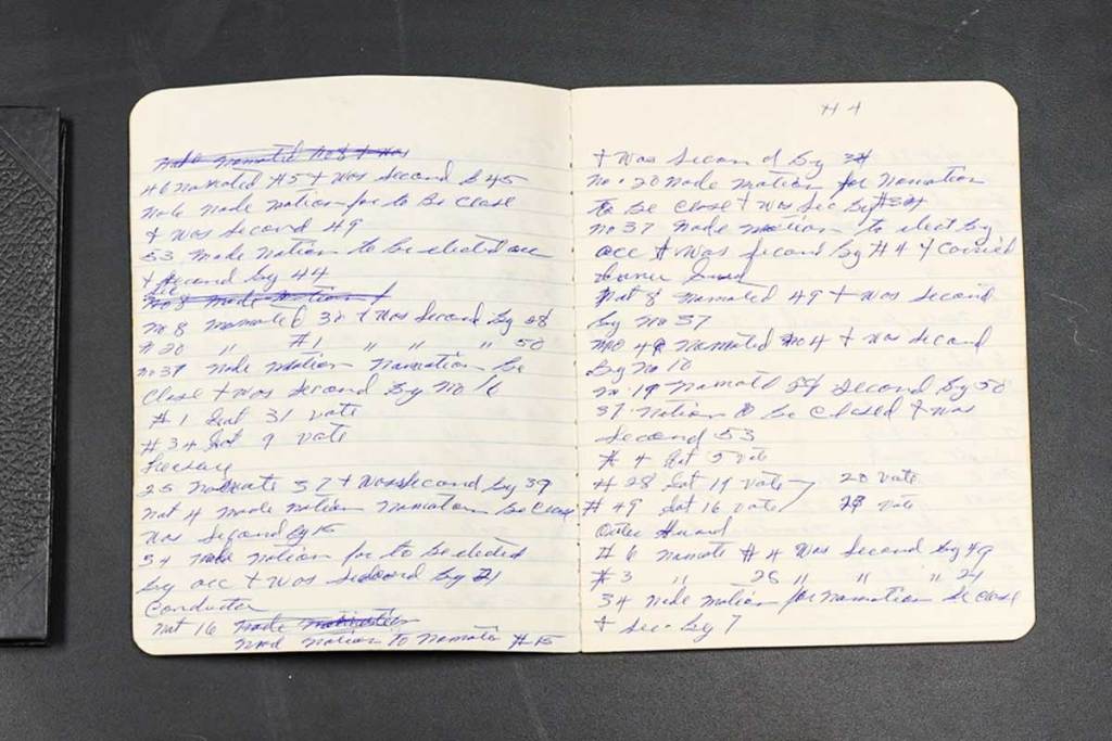 An open ledger filled with hand written notes in blue ink