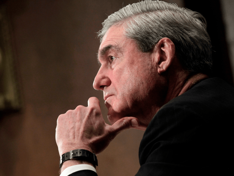 A closeup of Robert Mueller with his hand resting on his chin