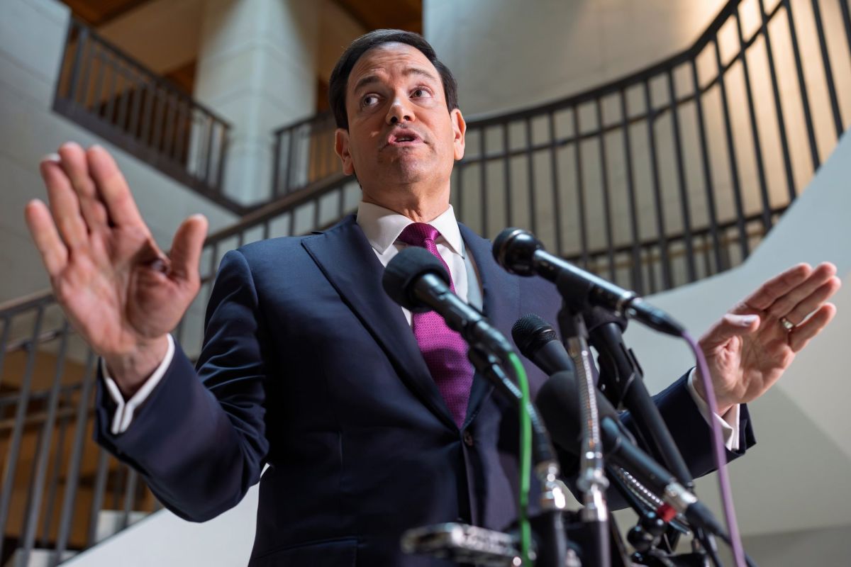 Maro Rubio speaks, arms spread out, at a podium