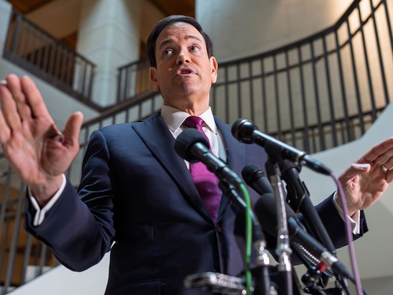 Maro Rubio speaks, arms spread out, at a podium