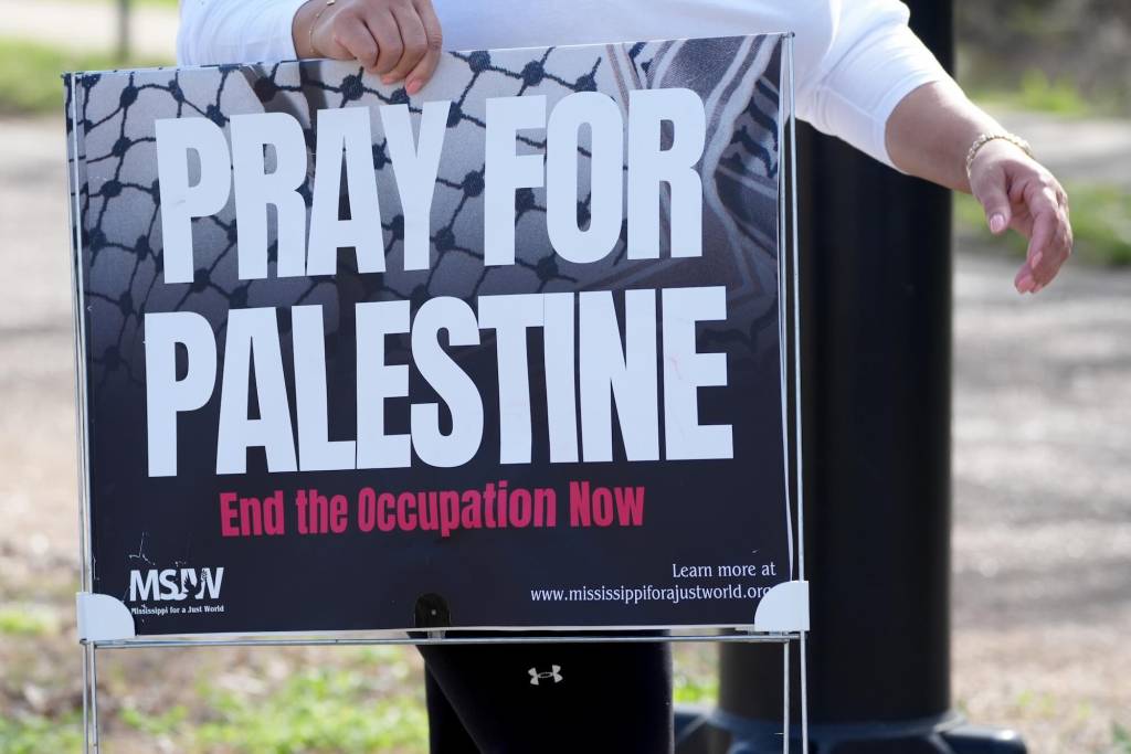 A closeup of a sign that reads 'Pray for Palestine. End the Occupation Now'