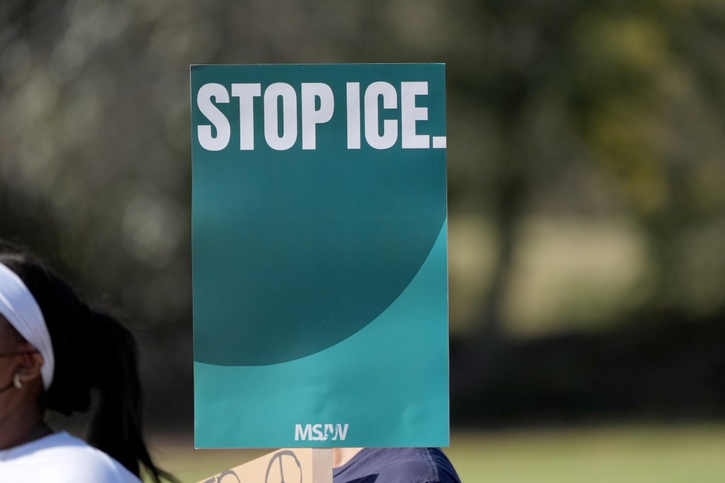 A closeup of a green sign that just reads 'Stop ICE'