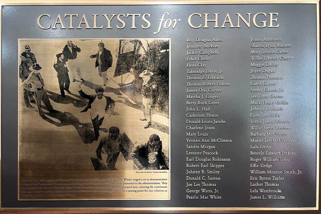 A plaque labeled 'Catalysts for Change' with an etching of a photograph on the left, and a list of names on the right