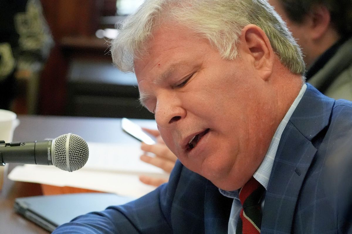 A closeup of Rob Roberson II leaning and speaking into a mic at a committee