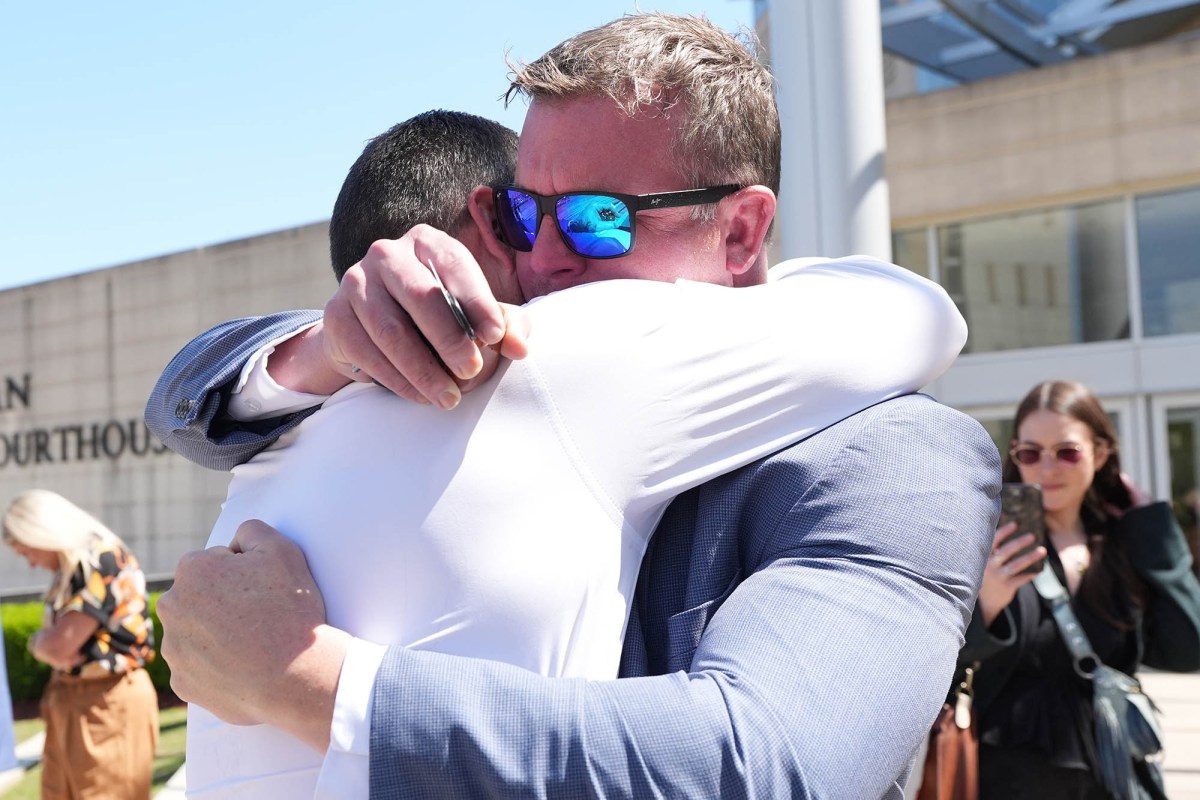 Brothers Ted DiBiase Jr. and Brett DiBiase hug outside a courthouse