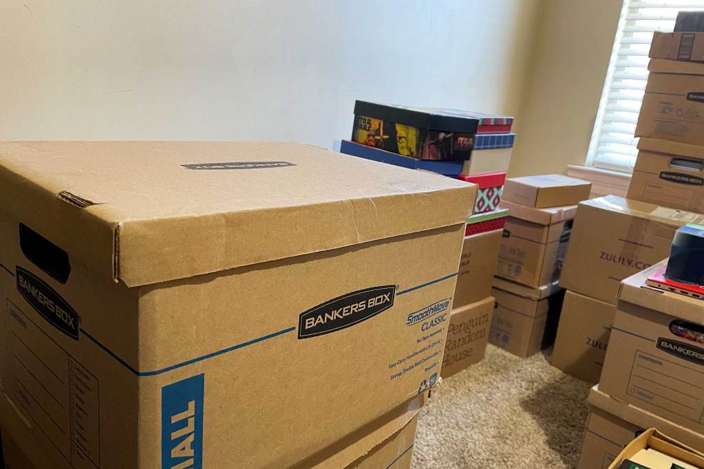 A room filled with stacks of brown banker boxes packed for moving