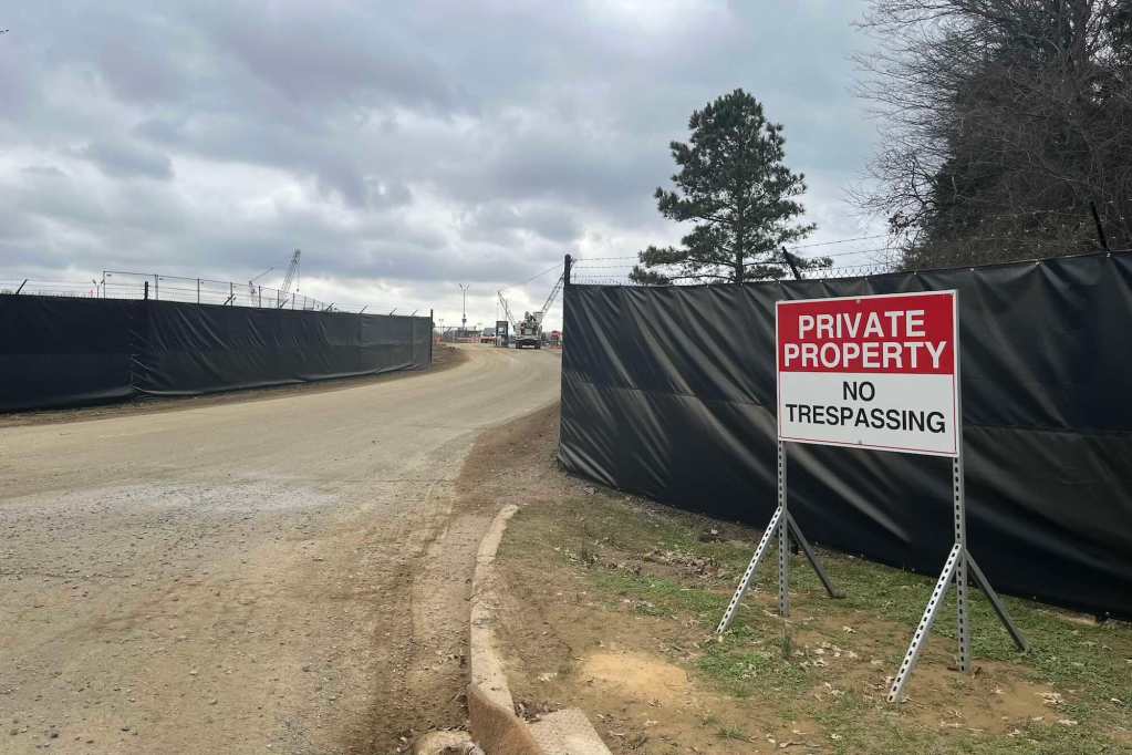 An entrance with covered fences and a sign that reads 'Private Property No Tresspassing'