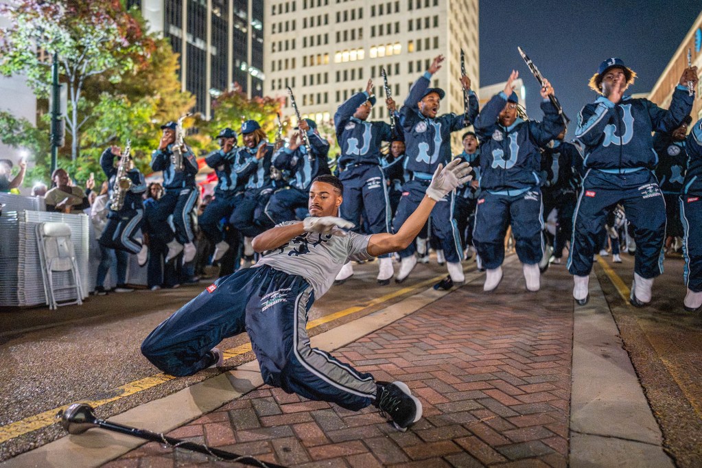 The JSU band, in blue tracks uits, perform at night in downtown Jackson, MS