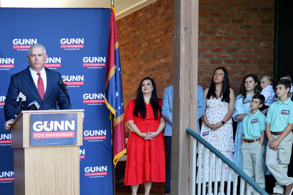 Philip Gunn speaks to supporters at an outside event, his family lining the space beside him