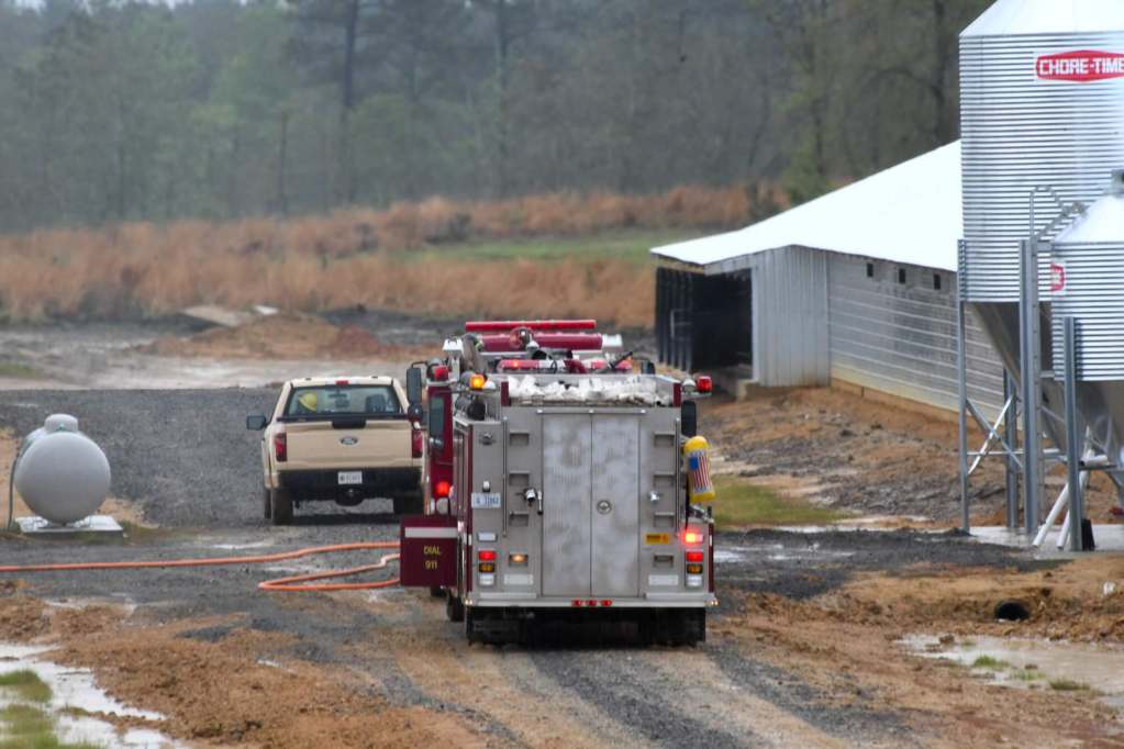A fire truck sits on a road between two buildings as it prepares to respond to a call.
