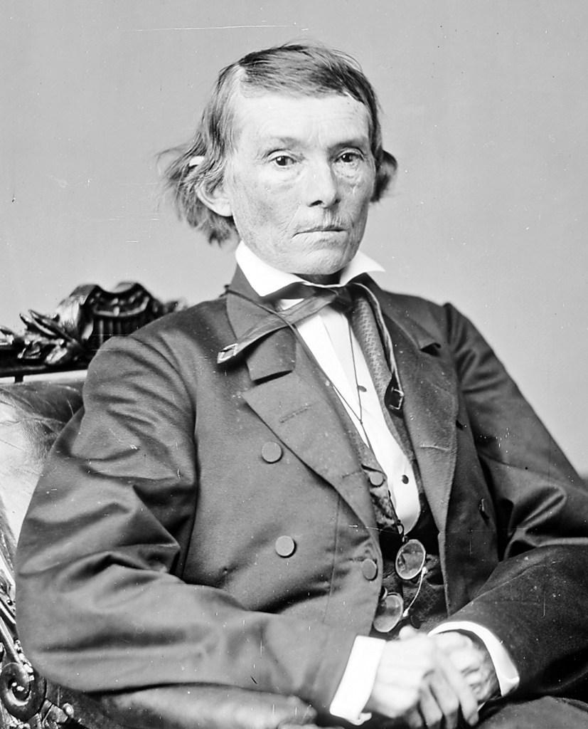 An old black and white portrait of Alexander Hamilton Stephens, wearing a suit and sitting in an armchair