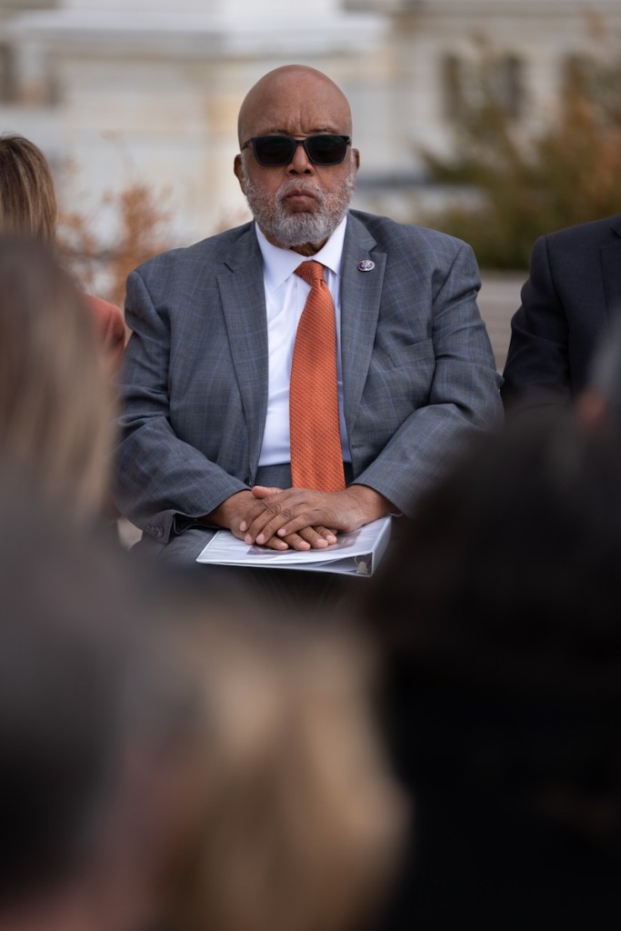 Bennie Thompson seen sitting outside in a suit and sunglasses at an event