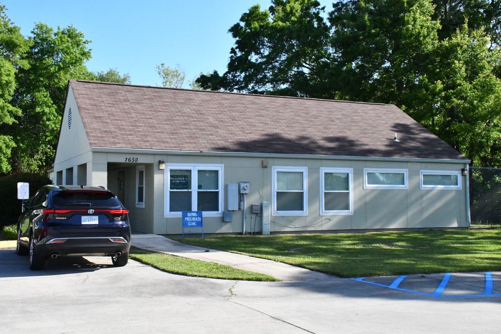 The Bethel Free Health Clinic building at Suncoast Villas with a car parked outside.